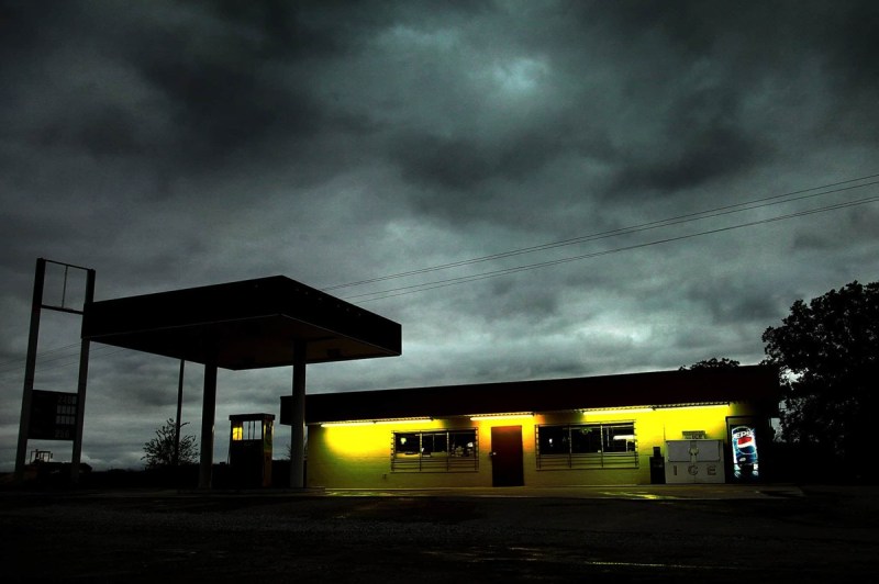 Looking from the street at a seedy gas station at night